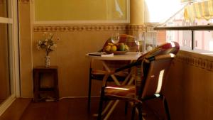una cocina con mesa y un bol de fruta en Apartamento Plumeria, en Algarrobo Costa