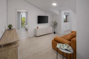 a living room with a couch and a tv at Apartment Complex Vetrina-Shared Pool in Nova Vas