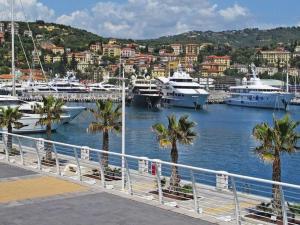 a marina with boats in a harbor with palm trees at Vicino al mare sulla pista ciclabile in Imperia