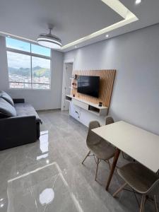 a living room with a couch and a table at Apartamento 2 quartos na baixada in São Vicente