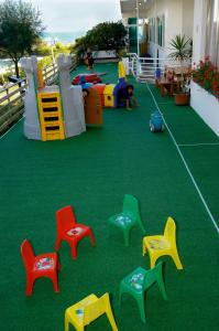 un parque infantil con sillas coloridas en el balcón en Hotel Beny, en Lido di Jesolo