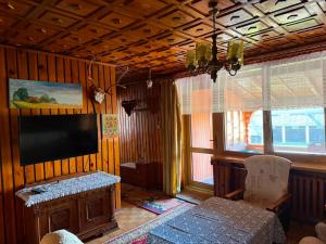 a living room with a flat screen tv and a table at Pokoje u Janeczki in Jałowo