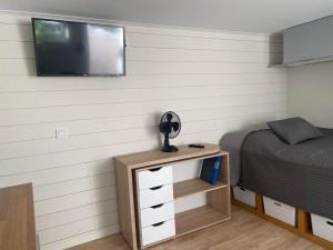 a bedroom with a bed and a television on a wall at Centralt Semesterboende in Halmstad