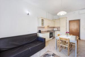 a living room with a black couch and a kitchen at Vicino al mare sulla pista ciclabile in Imperia