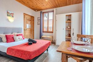 a bedroom with a bed and a dining table at PINOT GRIS - Charmant studio au cœur du vignoble - parking gratuit in Riquewihr