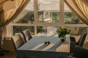 a dining room table with a vase of flowers on it at Haus Isabel in Büsum