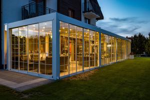a large glass building with furniture inside of it at Perla Mare Apartamenty in Krynica Morska