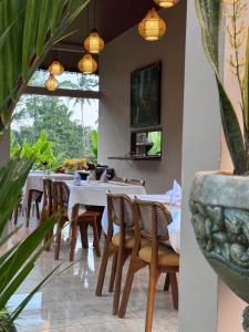 a dining room with tables and chairs and plants at Tanah Wuk Villas near ubud in Sangeh