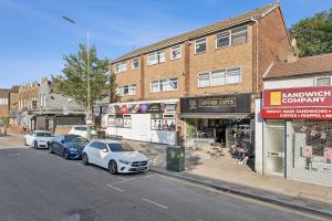 two cars parked on a street in front of buildings at K Suites - Nuxley Road in Bexley