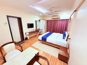 a hotel room with a bed and a table at Hotel Praveen International in Ulhāsnagar +49 photos