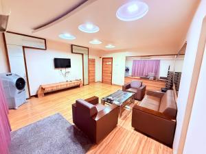 a living room with couches and a flat screen tv at Hotel Praveen International in Ulhāsnagar