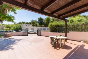 a patio with a table and chairs under a pergola at La villetta 451 in Fontanelle
