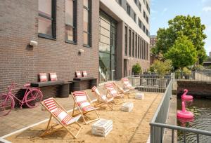 a group of chairs sitting on a patio next to a building at INNSiDE by Meliá Hamburg Hafen in Hamburg