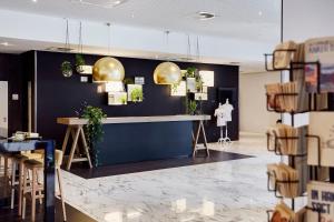 a room with a counter and some plants on a wall at INNSiDE by Meliá Hamburg Hafen in Hamburg