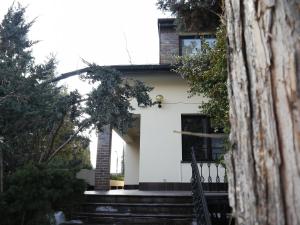a white house with a staircase in front of it at Guest House Villa Arkadia in Warsaw