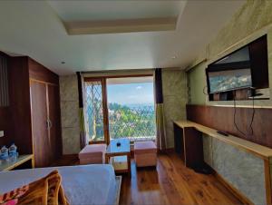 a living room with a large window and a television at The Town Boho in Shimla