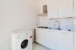 a kitchen with a washing machine and a sink at La villetta 451 in Fontanelle