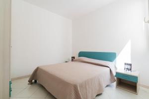 a bedroom with a bed with a blue head board at La villetta 451 in Fontanelle