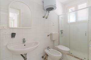 a bathroom with a sink and a toilet and a mirror at La villetta 451 in Fontanelle +19 photos