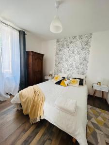 a bedroom with a large white bed with pillows at Gite d'Oliva in Suèvres