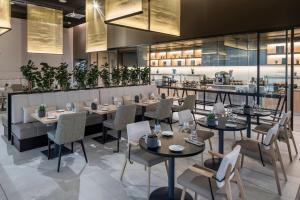 a restaurant with tables and chairs and a bar at Meliá Frankfurt City in Frankfurt +66 photos