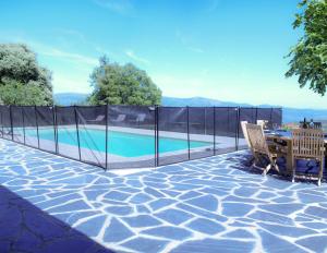 a fence around a swimming pool with a table and chairs at Mas Lartigues in Taurinya +12 photos