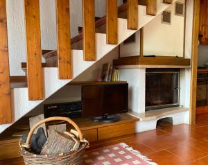 a living room with a tv and a staircase at Chalet Iris in Bertigo