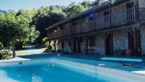 a house with a swimming pool in front of a building at Mas Lartigues in Taurinya