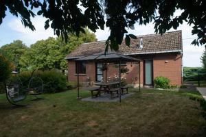 a picnic table in front of a brick building at La Pierraille in Froid-Chapelle