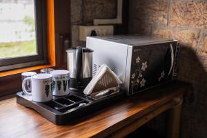 a microwave sitting on top of a counter with mugs at Nohsngithiang Estate in Borpāni