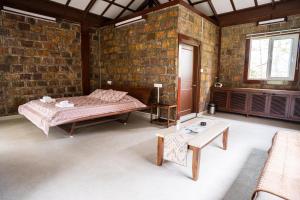a room with a bed and a table in it at Nohsngithiang Estate in Borpāni +25 photos