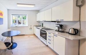 a kitchen with white cabinets and a table at 3 Bedroom Pet Friendly Apartment In Faaborg in Faaborg