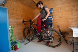 a man is holding a bike in a room at La Pierraille in Froid-Chapelle