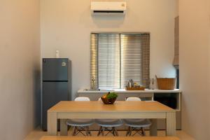 a kitchen with a table with chairs and a refrigerator at Neon Villa in Ko Phangan