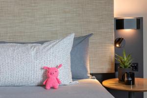 a pink teddy bear sitting on a bed with a pillow at INNSiDE by Meliá Luxembourg in Luxembourg +43 photos