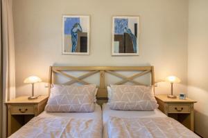 a bedroom with a bed with two nightstands and two lamps at Haus am Wald in Münstertal