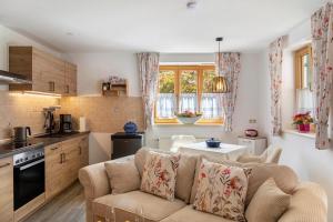 a kitchen and living room with a couch and a table at Haus Christian und Hanni in Bad Kohlgrub