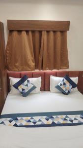 a bed with blue and white pillows on it at Hotel G17 Dhamnod in Dhāmnod +6 photos