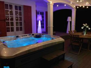 a jacuzzi tub in a room with a table at Villa Bourbon Pointu - Hiking & Spa in La Plaine des Palmistes