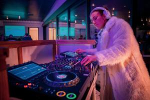 a woman is playing a dj in a room at Hotel Panorama in Clapham