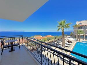 a balcony with a view of a pool and the ocean at Altamare Hotel in Kuşadası