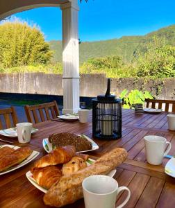 a table with croissants and pastries on a wooden deck at Villa Bourbon Pointu - Hiking & Spa in La Plaine des Palmistes