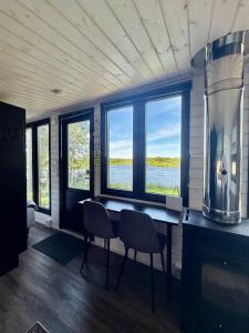 a room with a table and chairs and windows at Aurora Forest Cabin in Rovaniemi