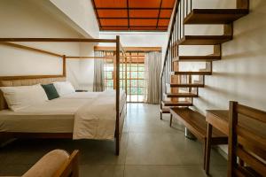 a bedroom with a bed and a spiral staircase at Serene Slopes in Vagamon