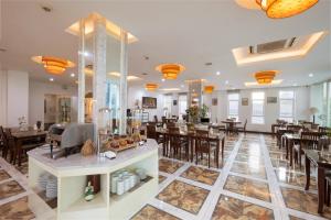 a dining room with tables and chairs and a restaurant at Phnom Penh Katari Hotel in Phnom Penh