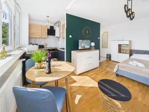a kitchen and a living room with a table and chairs at Śląskie Mieszkania in Będzin