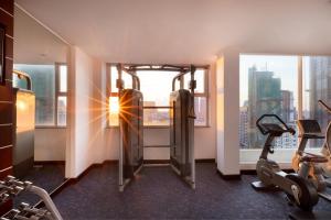 a gym with cardio equipment in a building with a window at Phnom Penh Katari Hotel in Phnom Penh