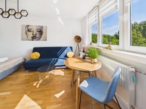 a living room with a table and chairs and windows at Śląskie Mieszkania in Będzin