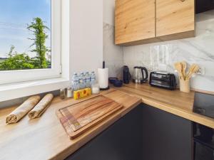 a kitchen counter with a cutting board and a window at Śląskie Mieszkania in Będzin