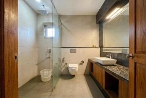 a bathroom with a toilet and a glass shower at Serene Slopes in Vagamon +29 photos